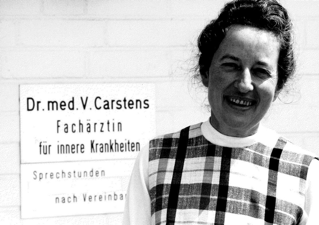 Dr. Veronica Carstens neben Praxisschild